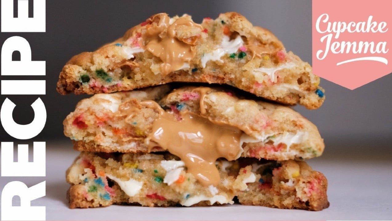 Close-up of gooey Birthday New York Cookies split open showing sprinkles and caramel with Cupcake Jemma recipe details.
