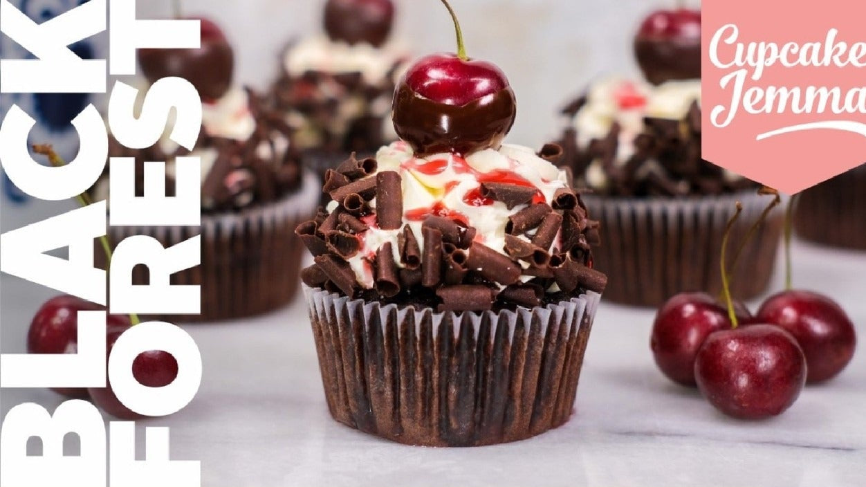 Chocolate Black Forest cupcake topped with cherry and cream with recipe ingredients by Cupcake Jemma