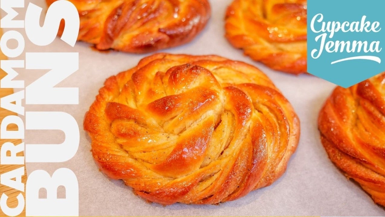Close-up of golden baked cardamom buns with Cupcake Jemma recipe ingredients for downloadable baking recipe.