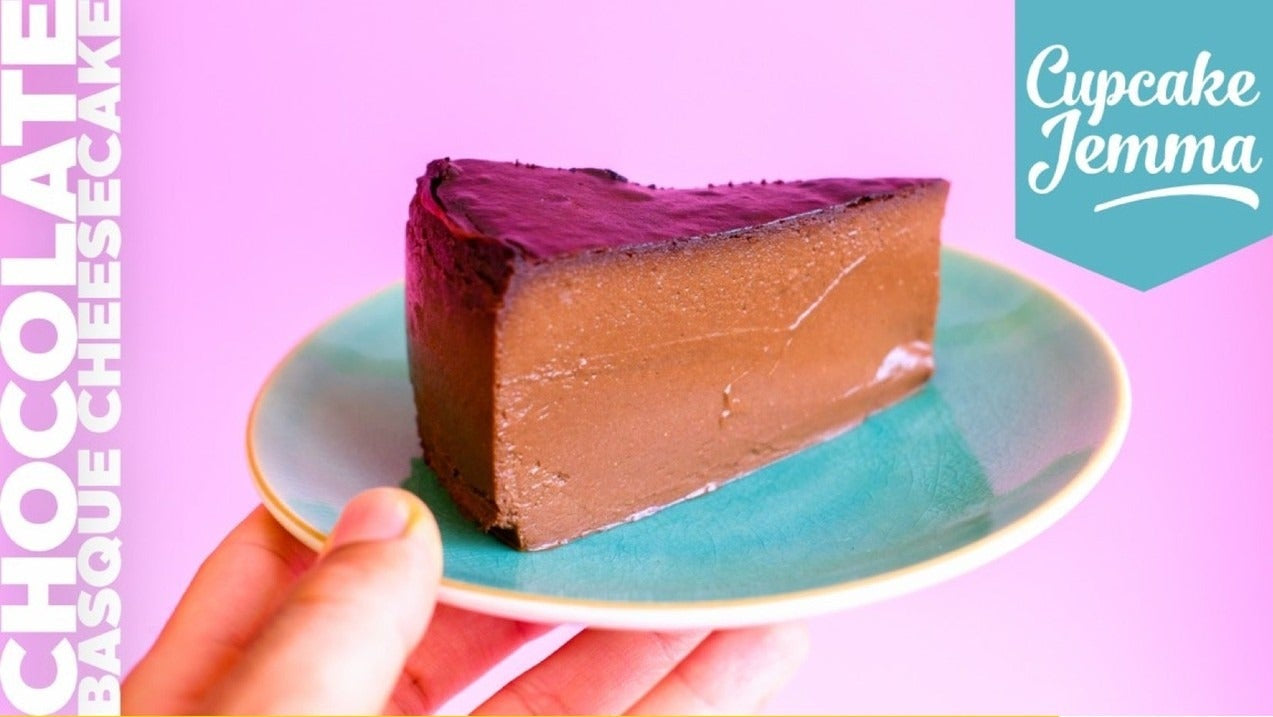 Slice of rich Chocolate Basque Cheesecake on a teal plate with recipe ingredients and Cupcake Jemma logo visible