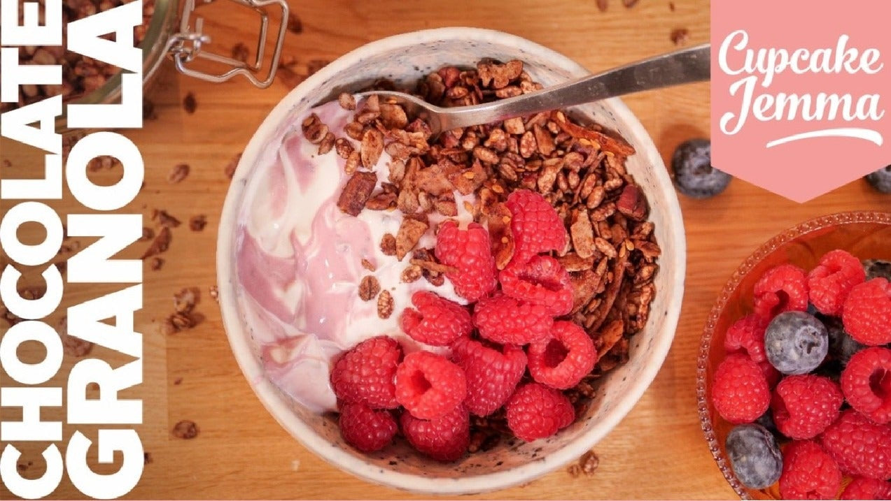 Bowl of chocolate granola with yogurt and fresh raspberries beside ingredients list for downloadable recipe