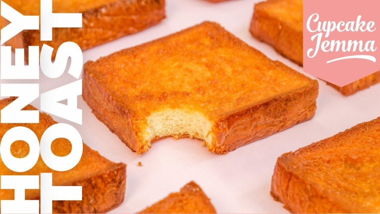 Crispy golden honey toast slice with a bite taken, showcasing the Honey Toast downloadable recipe by Cupcake Jemma.