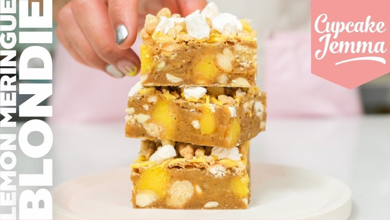 Stack of lemon meringue blondies with white chocolate and crumb topping on a plate from Cupcake Jemma recipe guide