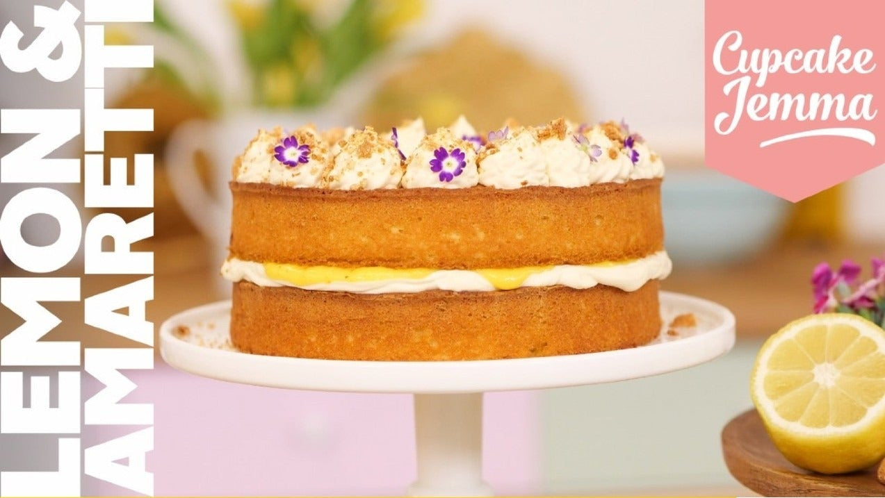 Lemon & Amaretti Cake on a stand with floral decorations, alongside recipe ingredients and Cupcake Jemma branding.