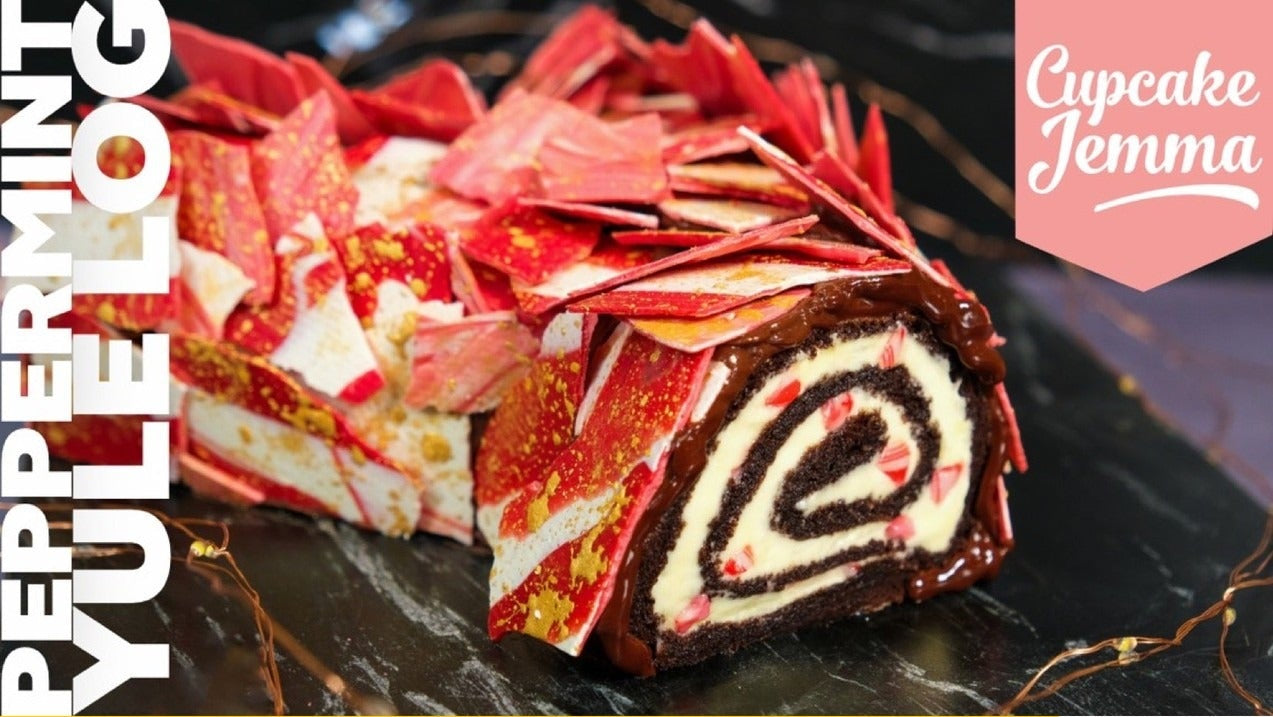 Close-up of a Peppermint Yule Log cake slice with red and white decoration, featuring a chocolate spiral cream filling