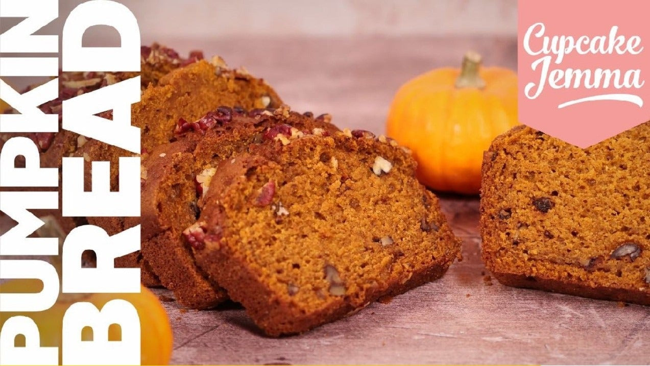 Sliced moist pumpkin bread with nuts and spices on a rustic surface with small pumpkins nearby and recipe text overlay