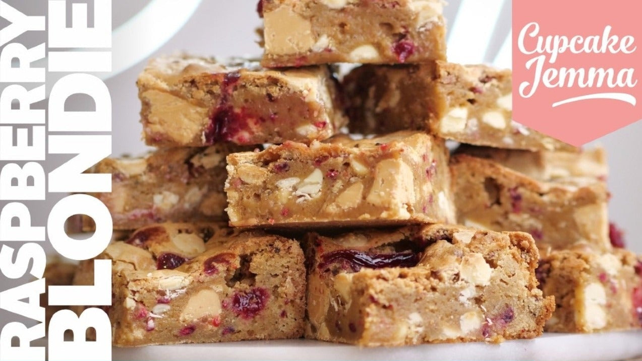 Stacked raspberry blondies with white chocolate chips featured in the downloadable Raspberry Blondie recipe by Cupcake Jemma.