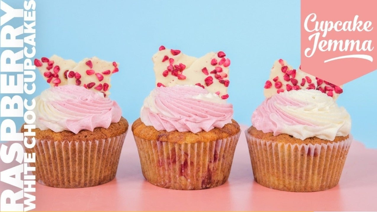 Three Raspberry White Chocolate Cupcakes with pink and white frosting and decorative white chocolate bark by Cupcake Jemma