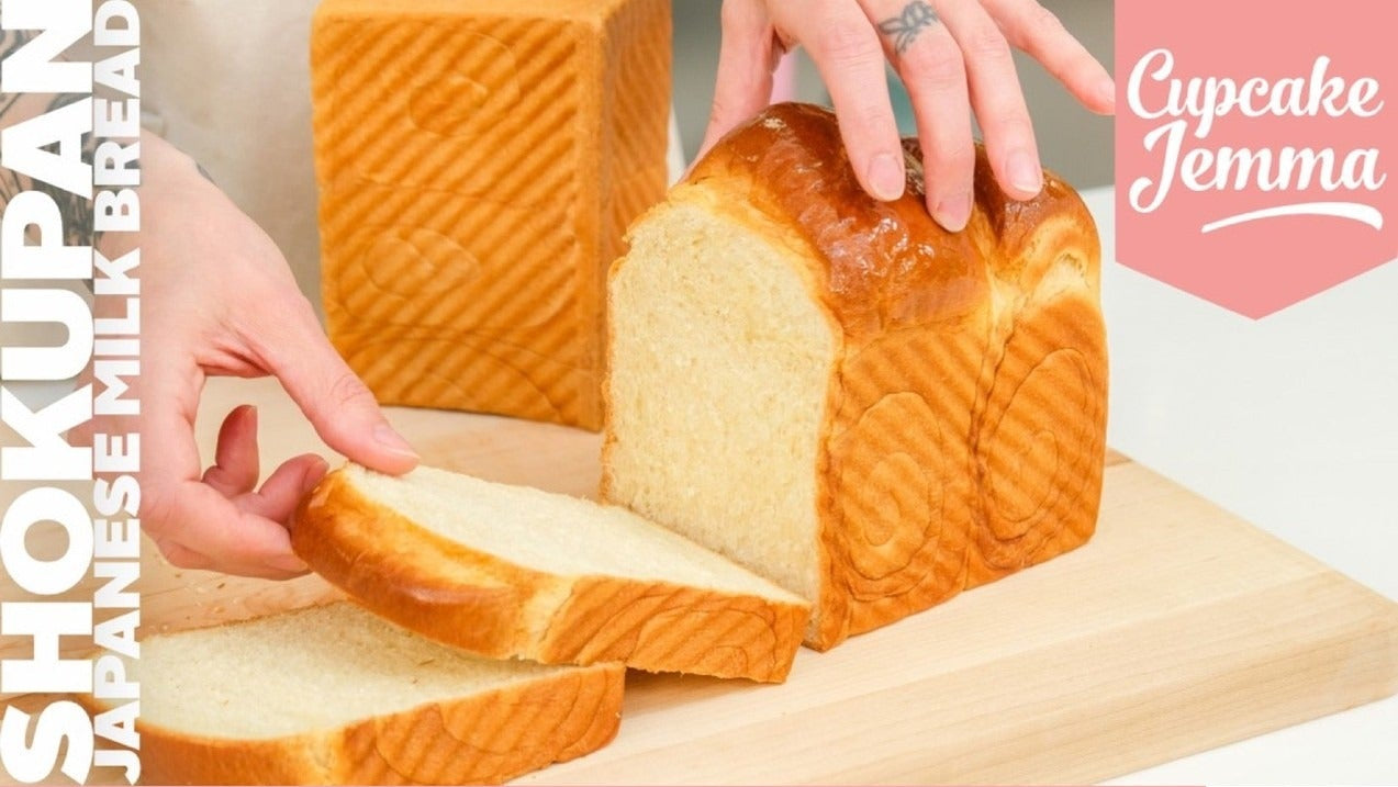 Hands slicing soft golden loaf of Shokupan Bread with recipe ingredients listed and Cupcake Jemma branding visible
