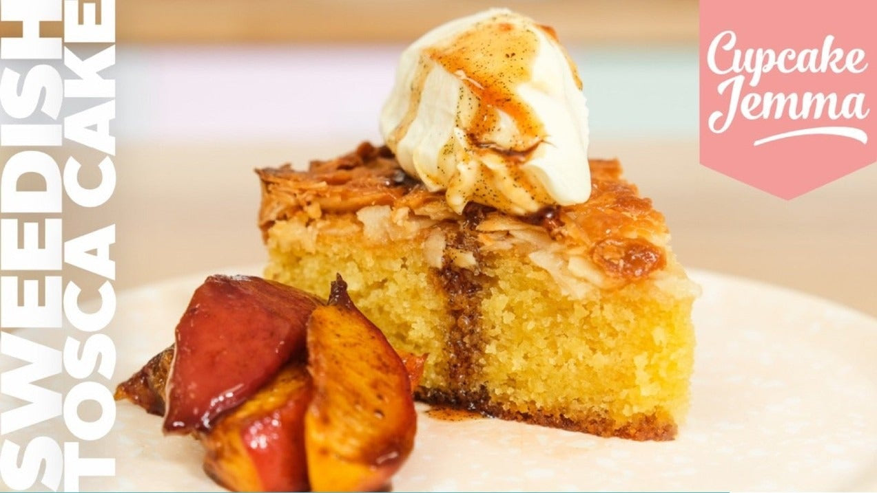 Slice of Swedish Tosca Cake topped with cream and caramelized almond flakes with roasted fruit on the side