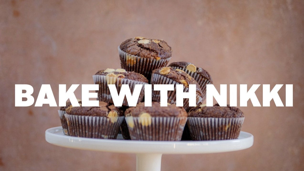 Stack of triple chocolate muffins on a white stand with Bake with Nikki text and ingredients list below