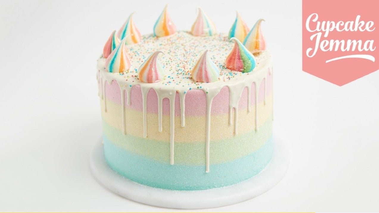 Pastel rainbow layered cake with colorful meringue decorations and white chocolate drip from Unicorn Cake downloadable recipe by Cupcake Jemma