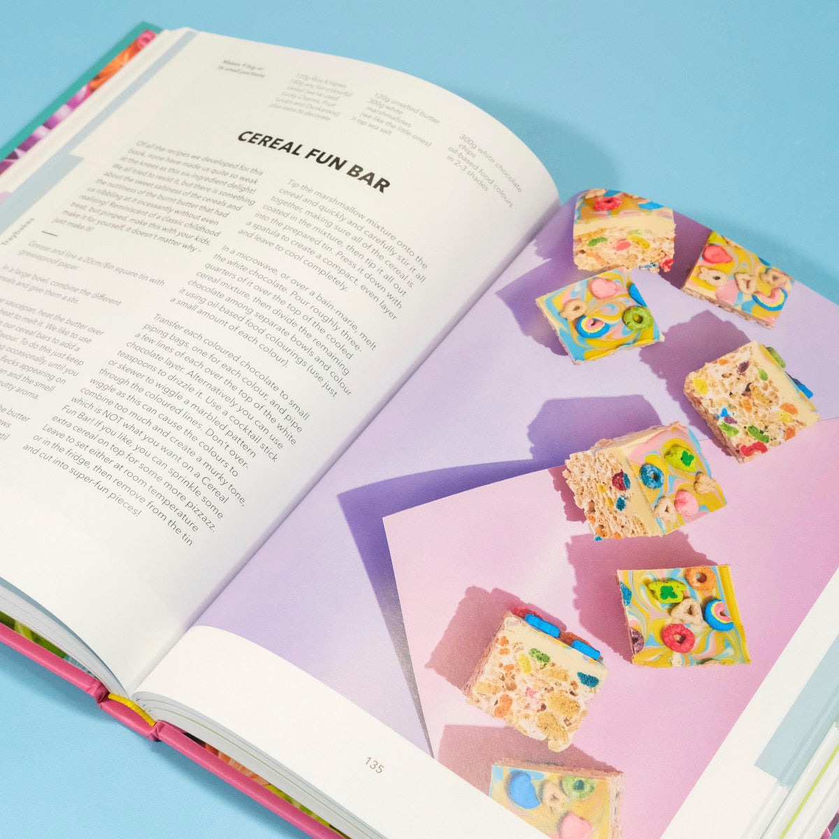 Open pages of The Crumbs & Doilies Recipe Book showing a colorful cereal fun bar recipe by Cupcake Jemma.