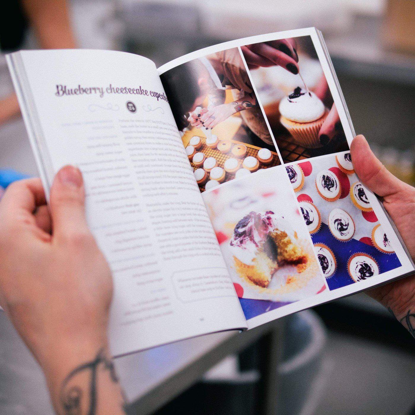 Open pages of The Cake Book by Cupcake Jemma showing blueberry cheesecake cupcake recipe with photos and baking steps