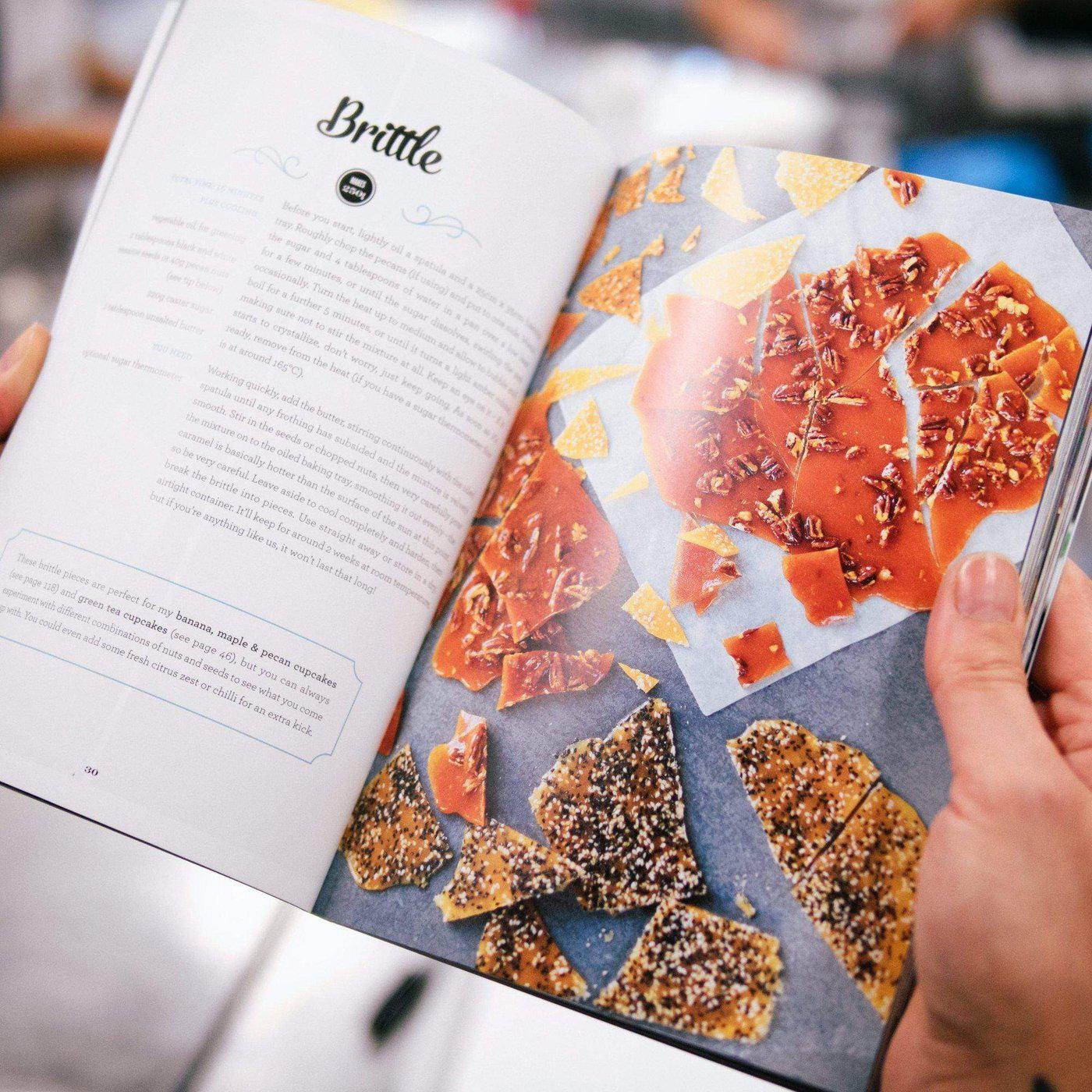 Open pages of The Cake Book by Cupcake Jemma showing brittle recipe with detailed instructions and photos of brittle pieces