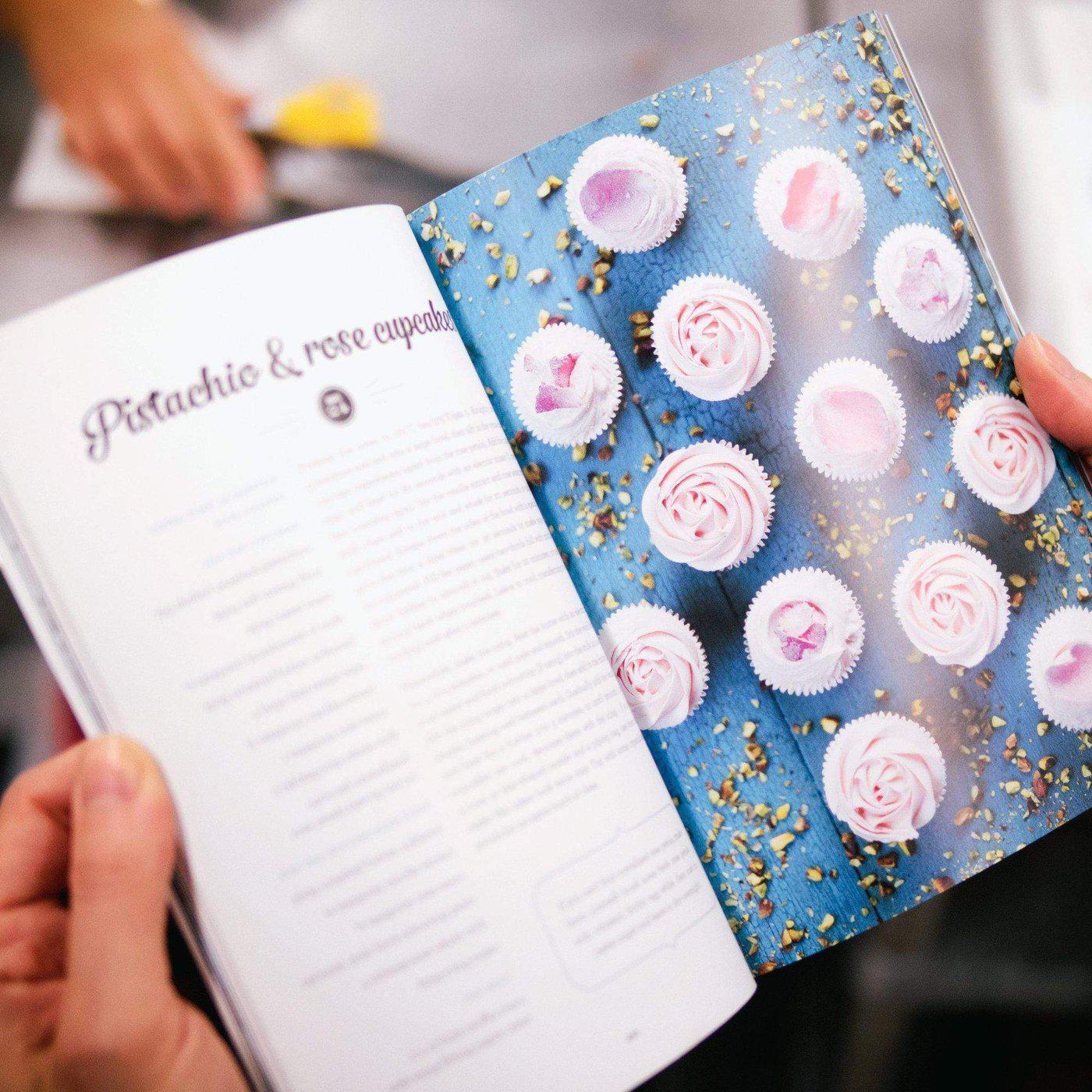 Open pages of The Cake Book by Cupcake Jemma showing pistachio and rose cupcake recipe with images of decorated cupcakes