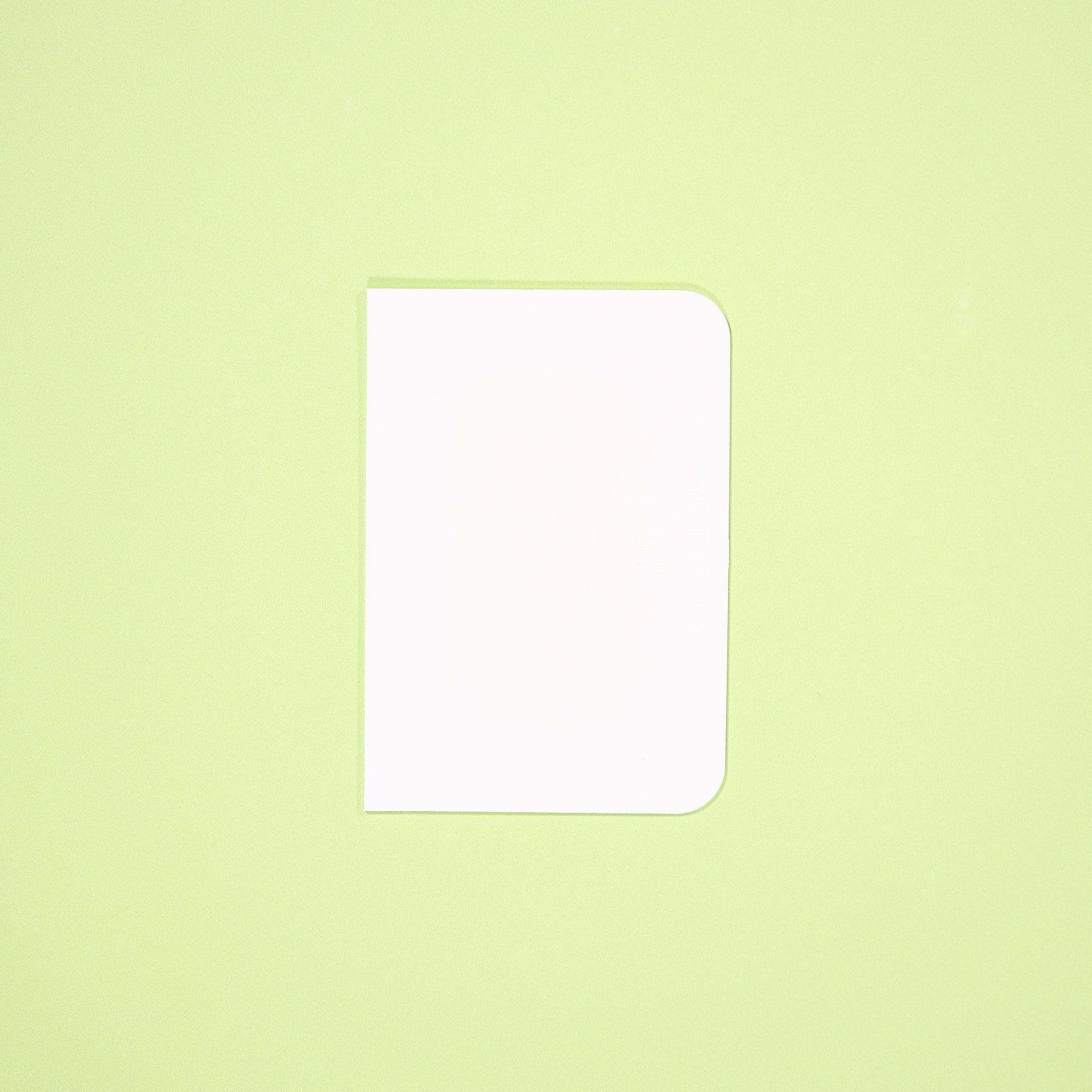 White Cake Scraper with rounded edge on light green background for smooth cake icing and clean edges in baking