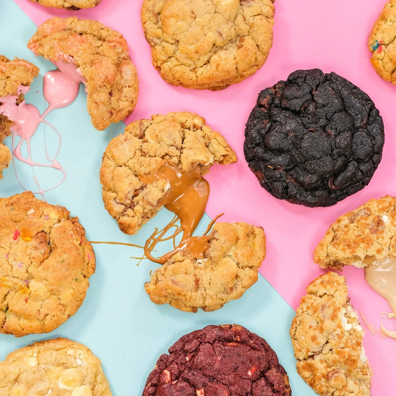 Freshly Baked New York Cookies with gooey fillings on a colorful pink and blue background showcasing Cupcake Jemma baking style